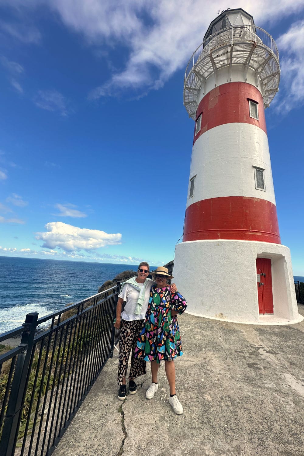 A man and a woman stand together on a street corner staring at a paper