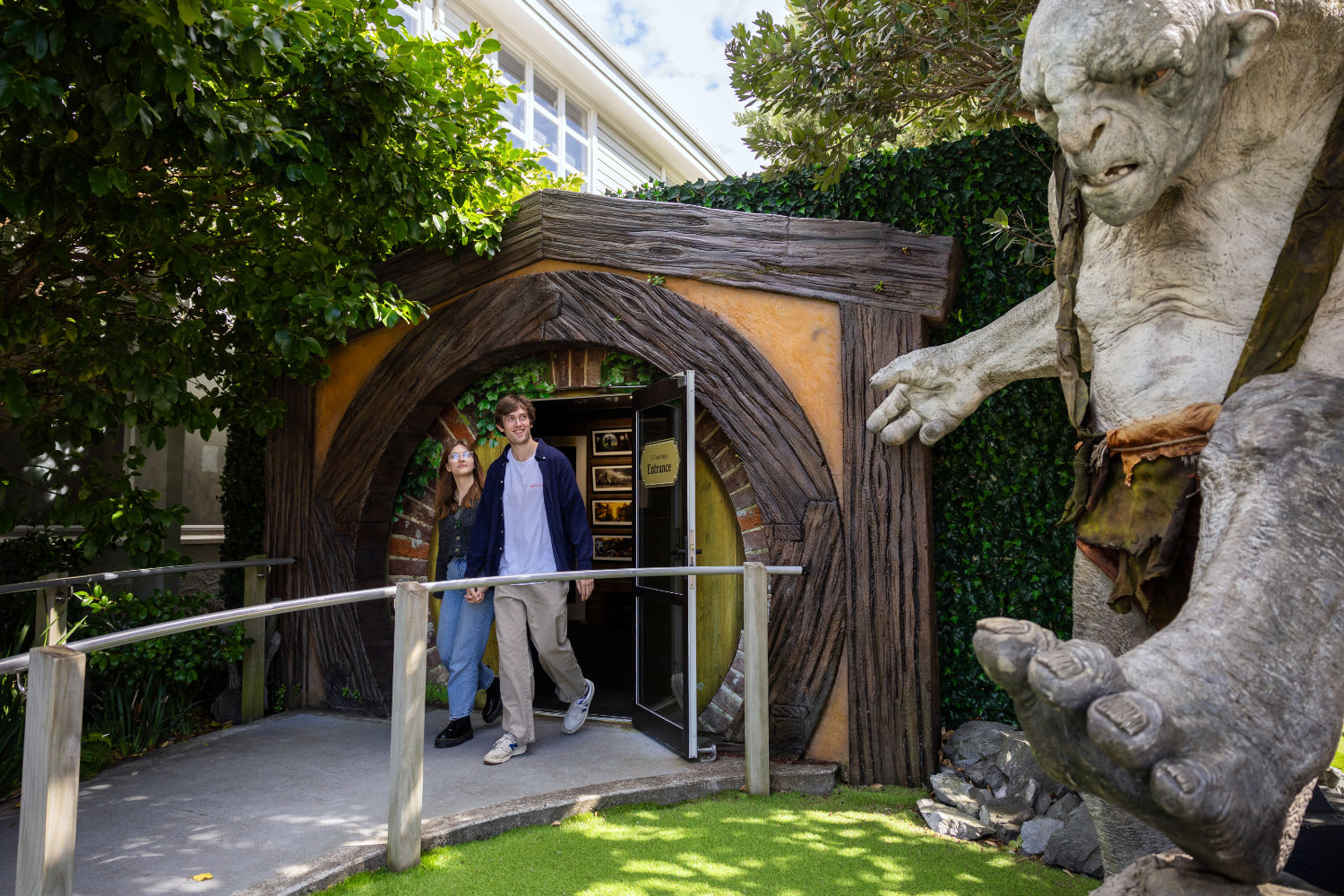 Three people are sitting at a table, doing their work and chatting a little.